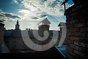 rooftop view on old historical buildings silhouettes against blue sky with white clouds