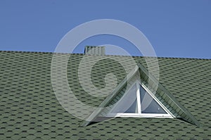 Rooftop with window against blue sky