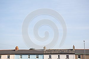 Rooftops in Bude, Cornwall with a blue sky.