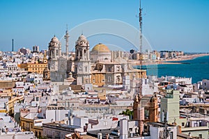 Rooftops of houses in aerial view of the medieval city of CÃÂ¡diz and towers and cupula of Cathedral de la Santa Cruz in seafront photo