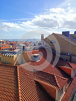 Rooftops of Lisbon houses on a sunny day overlooking the river and the ocean