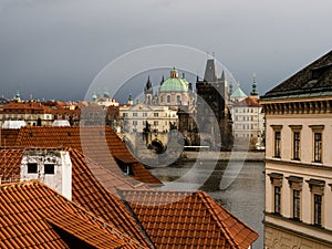 Rooftops of Mala Strana neighborhood with view of Charles Bridge in Prague