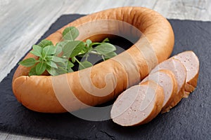 Rookworst sausage and basilÑŽ on slate cutting board