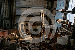 A Room in an Abandoned Building With Two Chairs Full of Debris and Very Old Objects