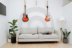 Room area for recreation. Sofa, guitars and TV