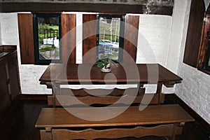 Room with bed, armchair, fireplace and wooden picnic table with a large veranda overlooking the lake of Valle de Bravo in Mexico