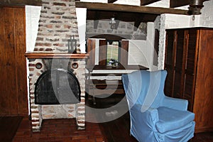 Room with bed, armchair, fireplace and wooden picnic table with a large veranda overlooking the lake of Valle de Bravo in Mexico