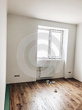 room floor renovation concept. stylish wooden laminate instalation, modern white walls. repairing and working in home, space for