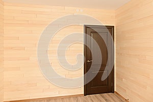 Room interior with a door sheathed by wooden boards