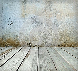 Room interior: grey old painted cement wall with wooden floor