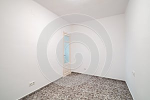 Room interior after renovation, unfurnished apartment with white walls, tiled floor and small door.