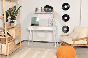 Room interior with stylish turntable on white table and vinyl records