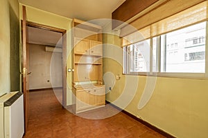 Room with light colored antique furniture, electric heat accumulator and double sliding aluminum windows