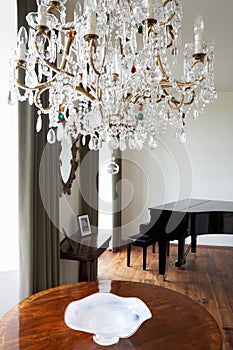 Room In Modern House With Chandelier And Grand Piano