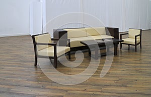 Room with parquet floor and white walls and minimalistic upholstered furniture