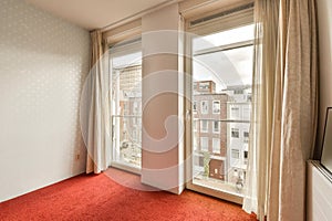 a room with a red carpet and two large windows