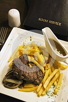 Room service. Mignon of beef and French fries with nut sauce