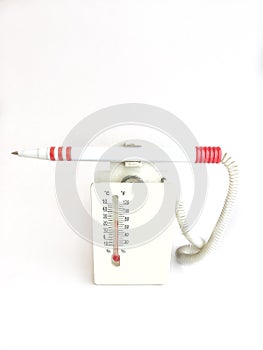 Room thermometer with a fountain pen on a stand on a white background.