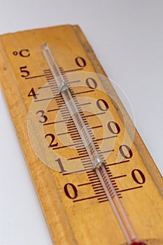 room thermometer on a wooden base close up on a white background. Celsius degree scale