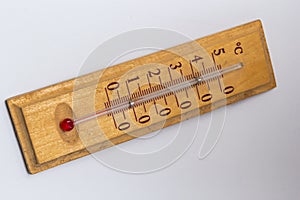 room thermometer on a wooden base close up on a white background. Celsius degree scale