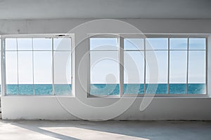a room with three windows overlooking the ocean