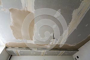Room under repair or building of new house or apartement. Suspended rough white ceiling of drywall not finished with spots of plas photo