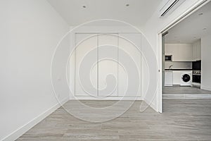 Room with wardrobe with three white wooden sliding doors