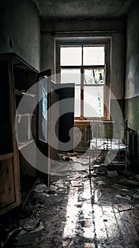 Room with a window with a bed in an abandoned house in Chernobyl