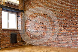 Room with a window, red brick walls and wooden flooring of boar