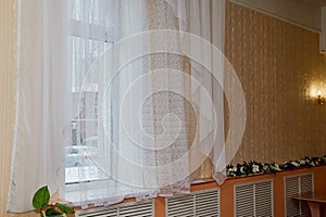 Room window with a white transparent tulle curtain