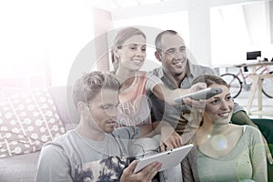 Roomates watching tv and using tablet