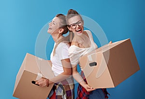 Roommates with a cardboard boxes and standing back to back