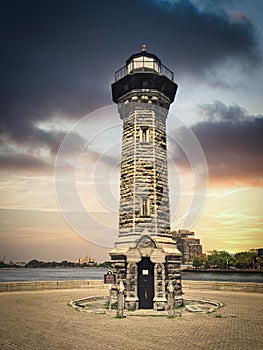 Roosevelt Island Lighthouse also known as Blackwell or Welfare. Lighthouse made of stones. View during stormy sunset