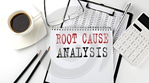 ROOT CAUSE ANALYSIS text on the paper with calculator, notepad, coffee ,pen with graph