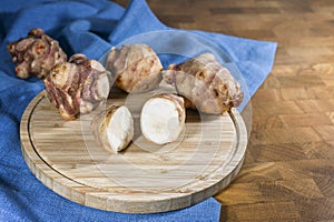 Root vegetable Jerusalem artichoke or topinambur (Helianthus tuberosus), on a rustic wooden kitchen board