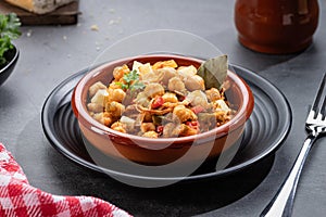 Ropa vieja, typical Canarian dish of chickpeas stew with chicken and potatoes in a earthenware casserole