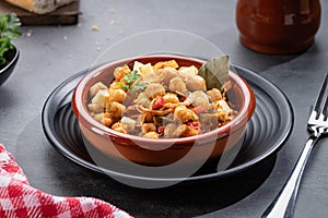 Ropa vieja, typical Canarian dish of chickpeas stew with chicken and potatoes in a earthenware casserole photo