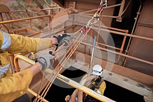 Rope access industry worker hand wearing hand safety glove protection, while using mechanical advantage three two one pulley