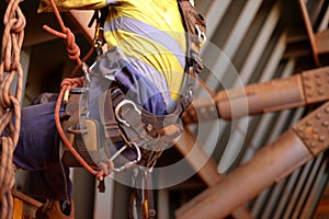 rope access inspector worker wearing full safety harness setting on a chair