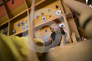 Rope access miner hand wearing a safety glove using battery rattle gun and fastening the bolts on construction site