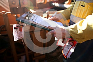 Rope access miner supervisor inspecting and checking name list on isolation permit holder box ensure all construction miners are l photo