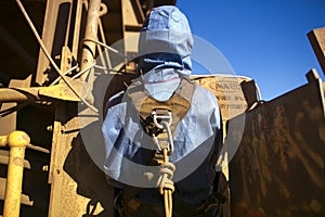 Rope access miner wearing safety harness connecting into Karabiner which attached on rope the back of his harness loop as rescue p