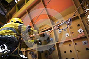 Rope access miner working at height hanging on harness commencing chute repairs which have secondary safety back up device knowing photo