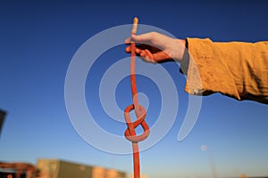 Rope access technician construction mine worker holding static 10.5 mm low stretch rope inspecting a figure of eight knot