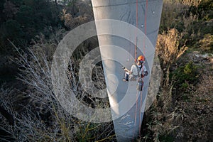 Rope access technician installing anchorages on concrete chimney