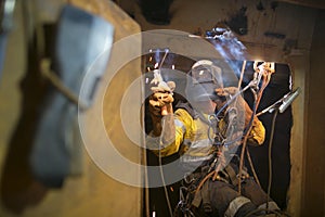 Rope access welder commencing welding in confined space