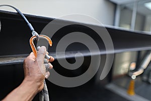 Rope access worker hand clipping locking Karabiner into first man up line