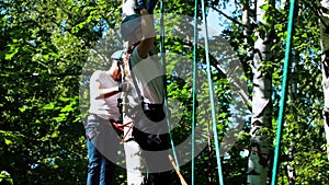 Rope adventure - young woman and man moving from one location to another