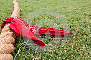 Rope With Bandana Lies On Grass Before Tug Of War