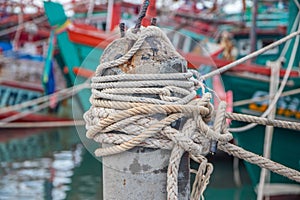 Rope bollard jetty or rope tied up on a pole on a wooden dock